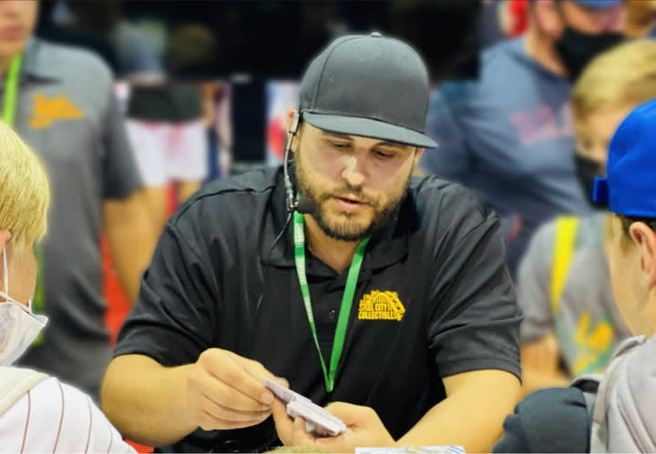 A Steel City Collectibles team member looks through a stack of sports cards with two young customers.