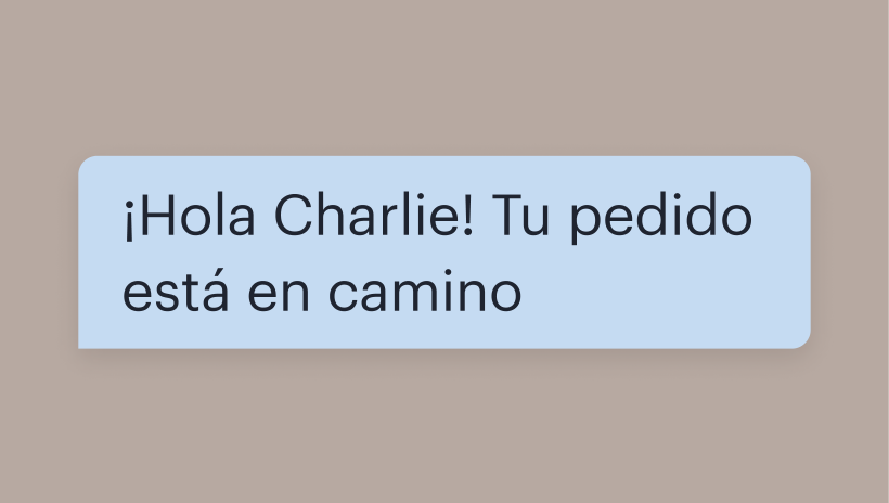 Una burbuja de texto SMS con el mensaje: "¡Hola, Charlie! Tu pedido está en camino"